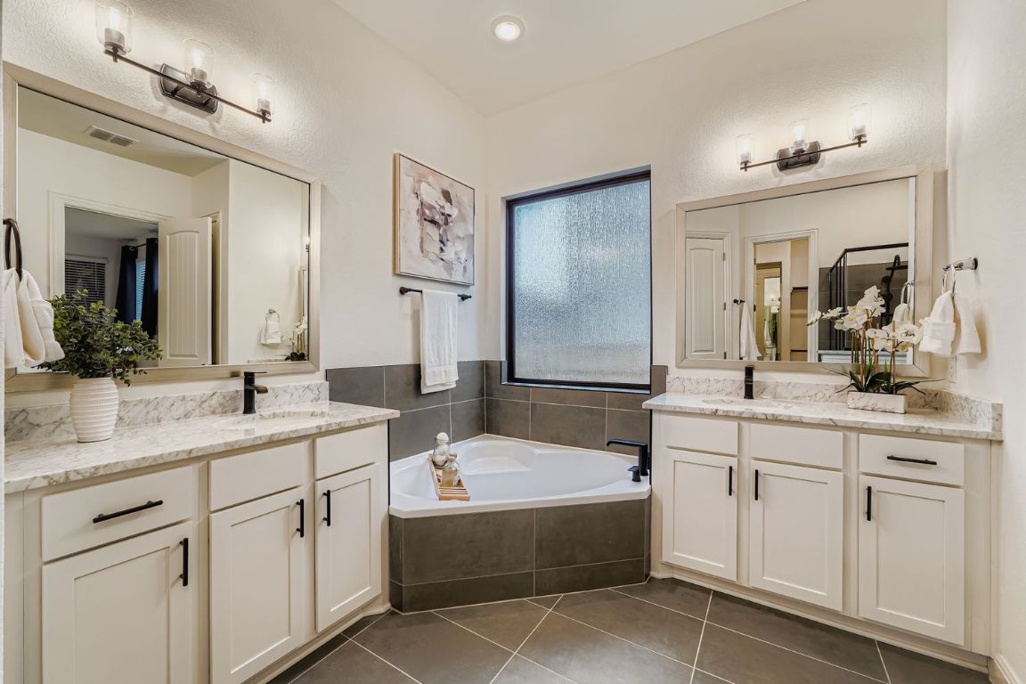 2928 Birdcall Path Leander, TX 78641 - Photo 20 of 36 a bathroom with a sink double vanity granite tub shower and a mirror