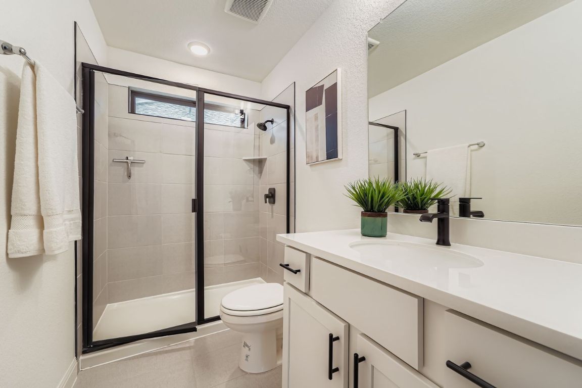 2928 Birdcall Path Leander, TX 78641 - Photo 25 of 36 a bathroom with a granite countertop sink a toilet and shower