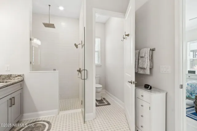 a spacious bathroom with a granite countertop sink a mirror and a shower