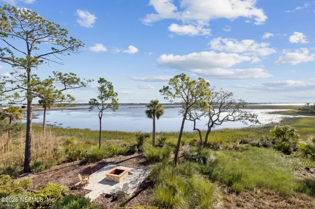 a kitchen with stainless steel appliances granite countertop a stove a sink dishwasher and white cabinets with wooden floor