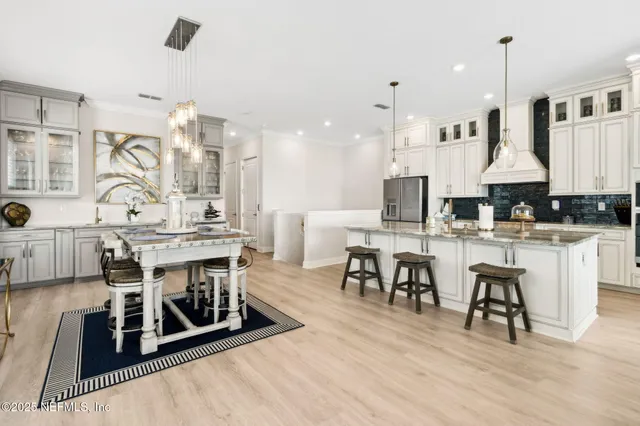 a kitchen with stainless steel appliances granite countertop a stove and a white cabinets