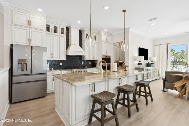 a kitchen with kitchen island a sink stove and refrigerator