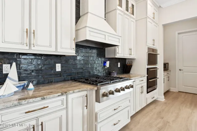 a kitchen with stainless steel appliances kitchen island granite countertop a table chairs sink and cabinets