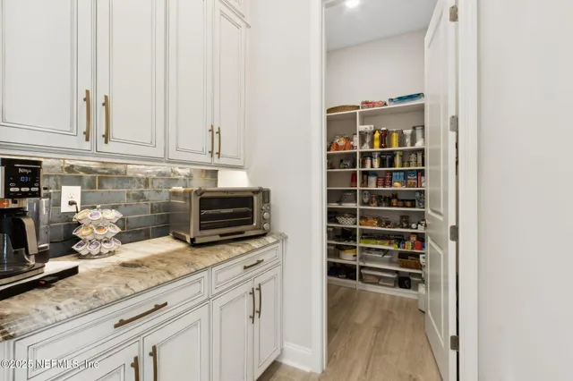 a bathroom with a granite countertop sink a toilet a mirror and shower