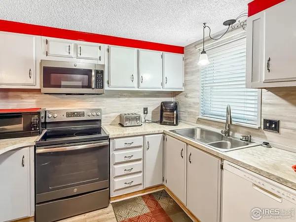 a kitchen with granite countertop a sink and stainless steel appliances