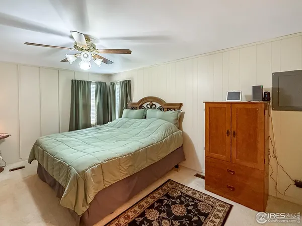 a bedroom with bed and wooden floor