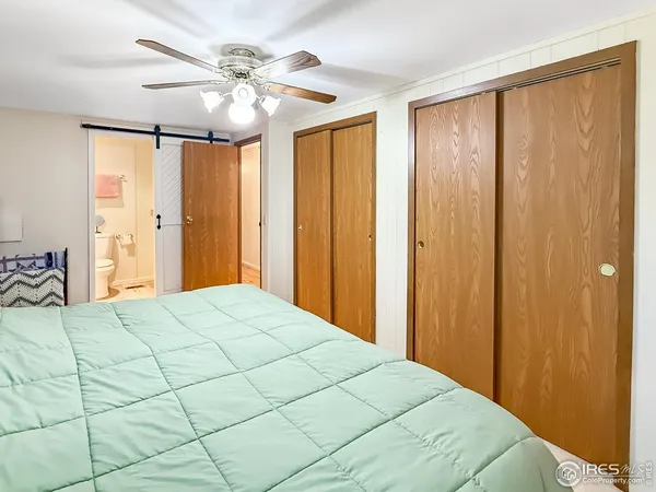 a bedroom with a large bed and a chandelier fan