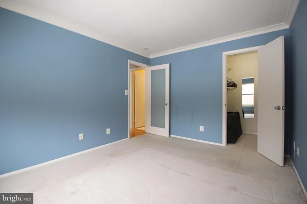 a view of an empty room with closet and a window