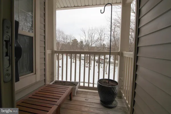 a view of a balcony with wooden floor and a potted plant