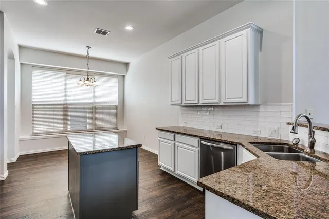 a kitchen with stainless steel appliances granite countertop a sink a stove and a wooden cabinets
