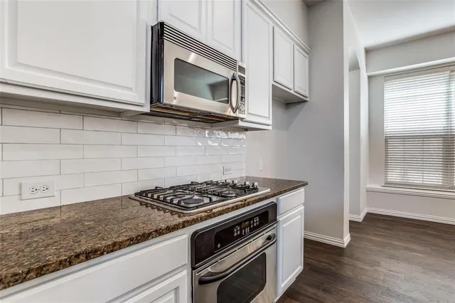 a kitchen with stainless steel appliances granite countertop a stove and a microwave