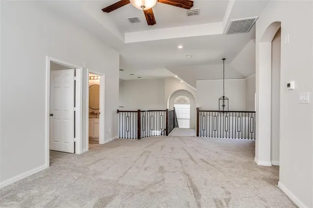 en empty room with ceiling fan and window