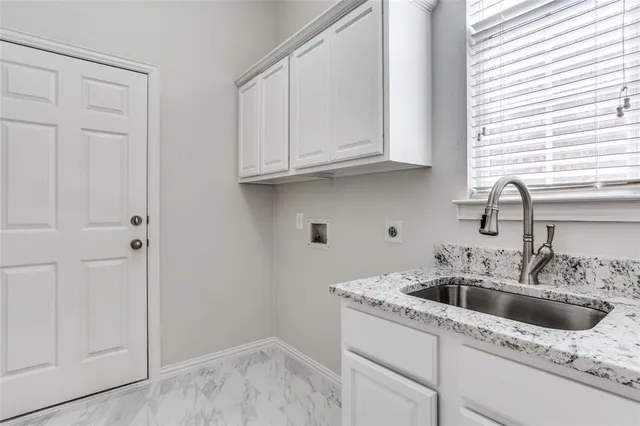 a kitchen with white cabinets and a sink