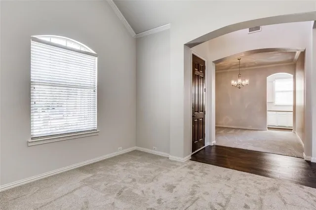 a view of a hallway with wooden floor and a window