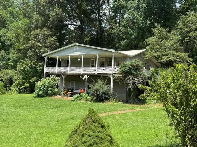 a front view of a house with a yard and trees