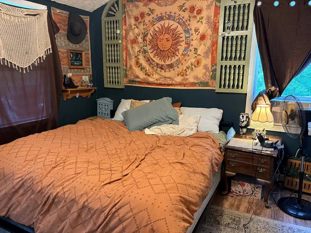 a bedroom with a bed and dresser next to a window