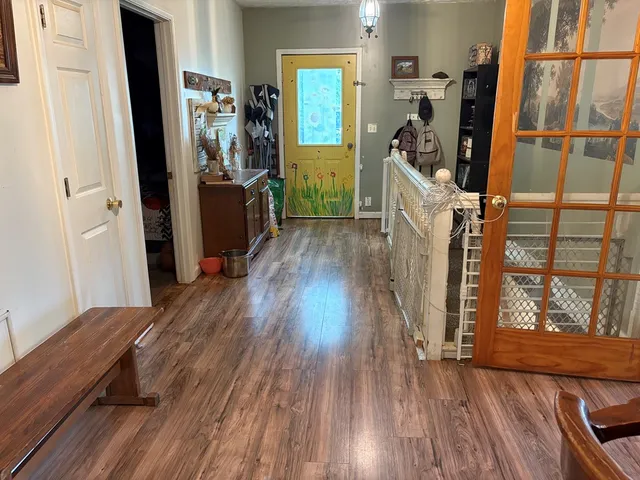 a view of a hallway with wooden floor and staircase