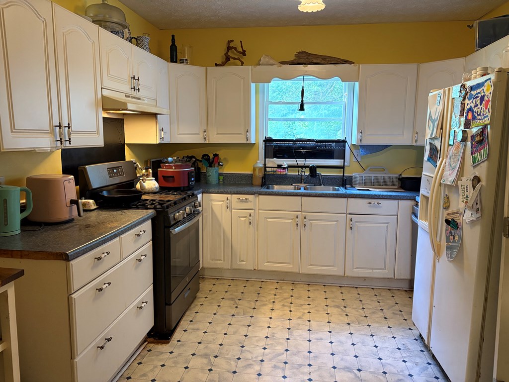 24 Doe Run Suches, GA 30572 - Photo 4 of 46 a kitchen with granite countertop a sink a stove a refrigerator and cabinets