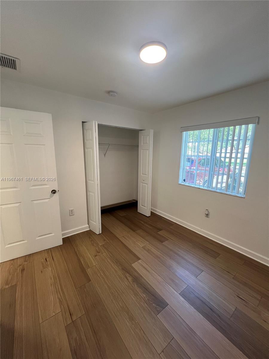 12254 Southwest 217th Street Miami, FL 33170 - Photo 13 of 29 an empty room with wooden floor and windows