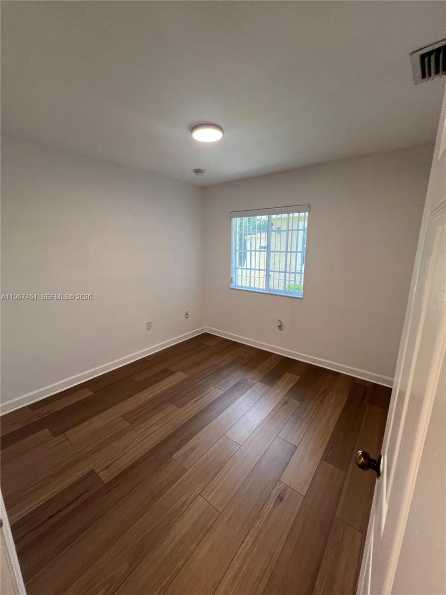 12254 Southwest 217th Street Miami, FL 33170 - Photo 21 of 29 an empty room with wooden floor and windows