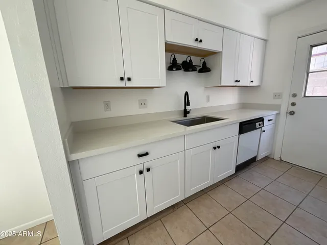 a kitchen with granite countertop white cabinets and white appliances