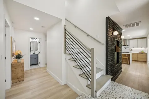 a view of a hallway view with staircase and kitchen view