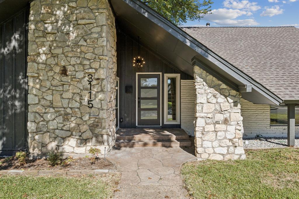 3115 Whirlaway Road Dallas, TX 75229 - Photo 26 of 28 Property entrance with stone siding, a shingled roof, and board and batten siding