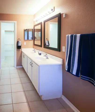 a spacious bathroom with a double vanity sink and a mirror
