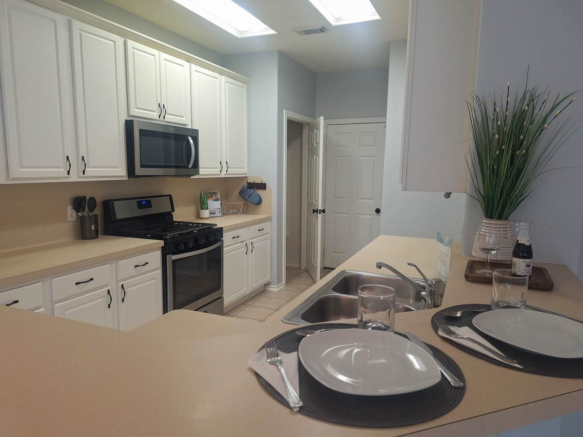 27 Summer Haze Circle Spring, TX 77382 - Photo 6 of 26 a kitchen with stainless steel appliances a sink a stove a microwave and cabinets