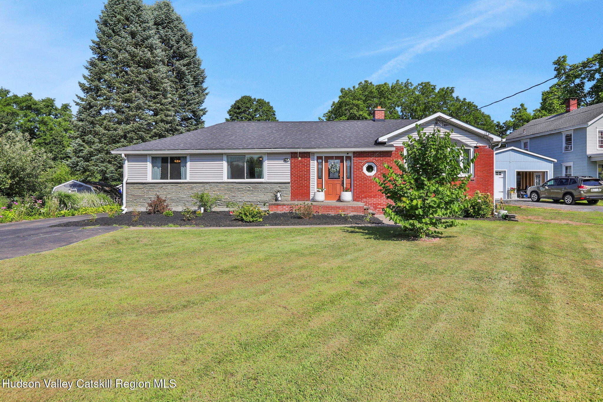 a front view of house with yard and trees in the background