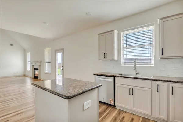 a kitchen with sink cabinets and wooden floor