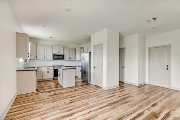 a kitchen with stainless steel appliances kitchen island granite countertop a refrigerator and a stove top oven