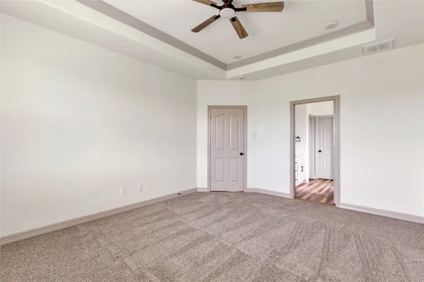 a view of a room with a ceiling fan and wooden floor