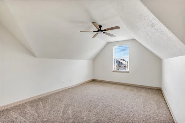 an empty room with a ceiling fan and window