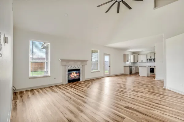 an empty room with windows and fireplace