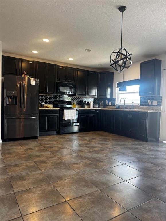 3837 Spring Creek Road Dundee, FL 33838 - Photo 3 of 15 a large kitchen with granite countertop a stove and refrigerator