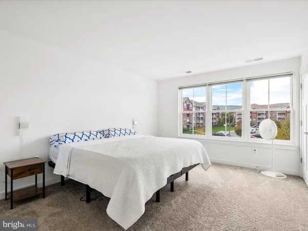 a bedroom with a bed and a large window