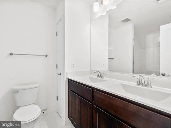 a bathroom with a granite countertop sink a toilet and a mirror