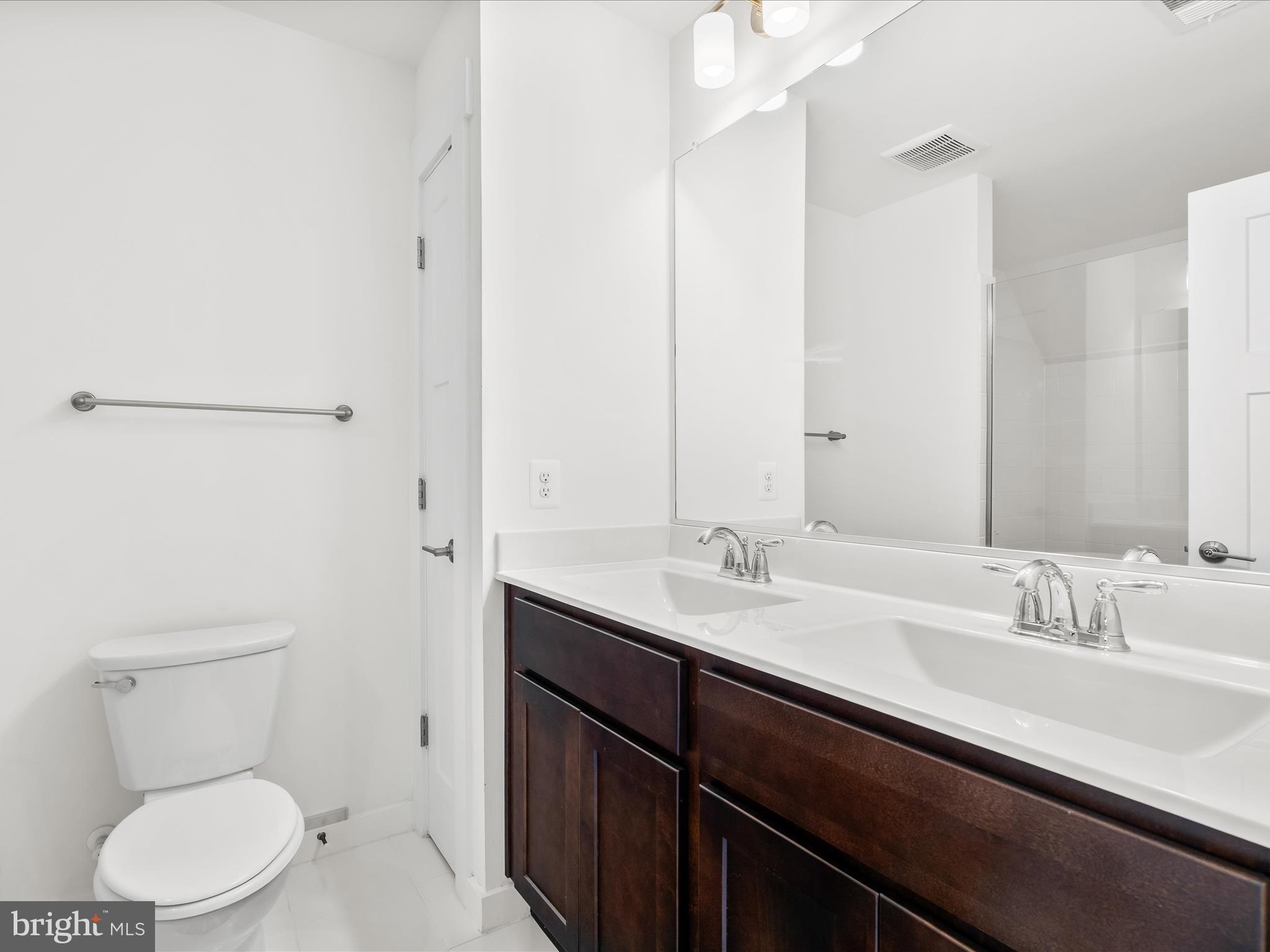 404 Waverley Drive Frederick, MD 21702 - Photo 24 of 28 a bathroom with a granite countertop sink a toilet and a mirror