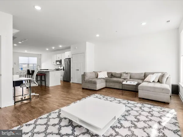 a living room with furniture and kitchen view
