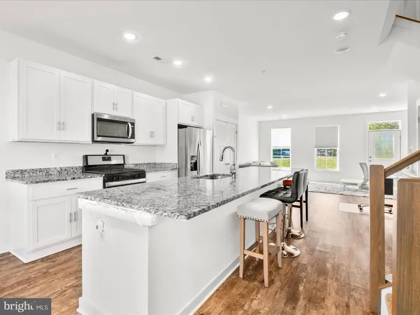 a kitchen with white cabinets and chairs