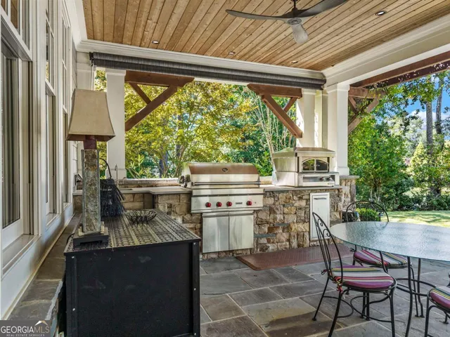a kitchen with a stove a table and chairs in it