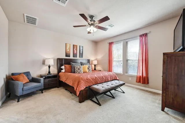 a spacious bedroom with a bed and a chandelier