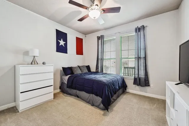 a spacious bedroom with a bed and a flat screen tv