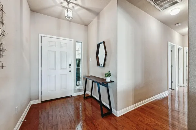 a view of a hallway with wooden floor and staircase