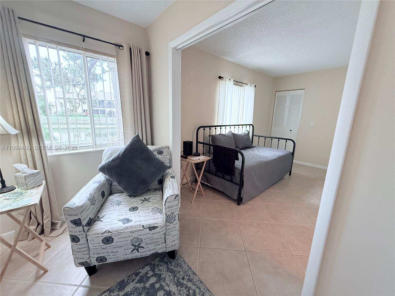 340 Pine Ridge Circle, Unit C1 Greenacres, FL 33463 - Photo 14 of 24 a living room with furniture and a large window