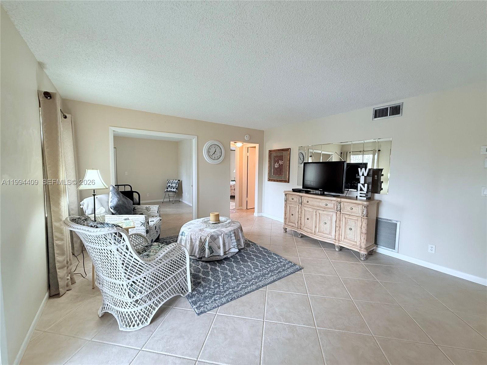 340 Pine Ridge Circle, Unit C1 Greenacres, FL 33463 - Photo 15 of 24 a living room with furniture and a flat screen tv