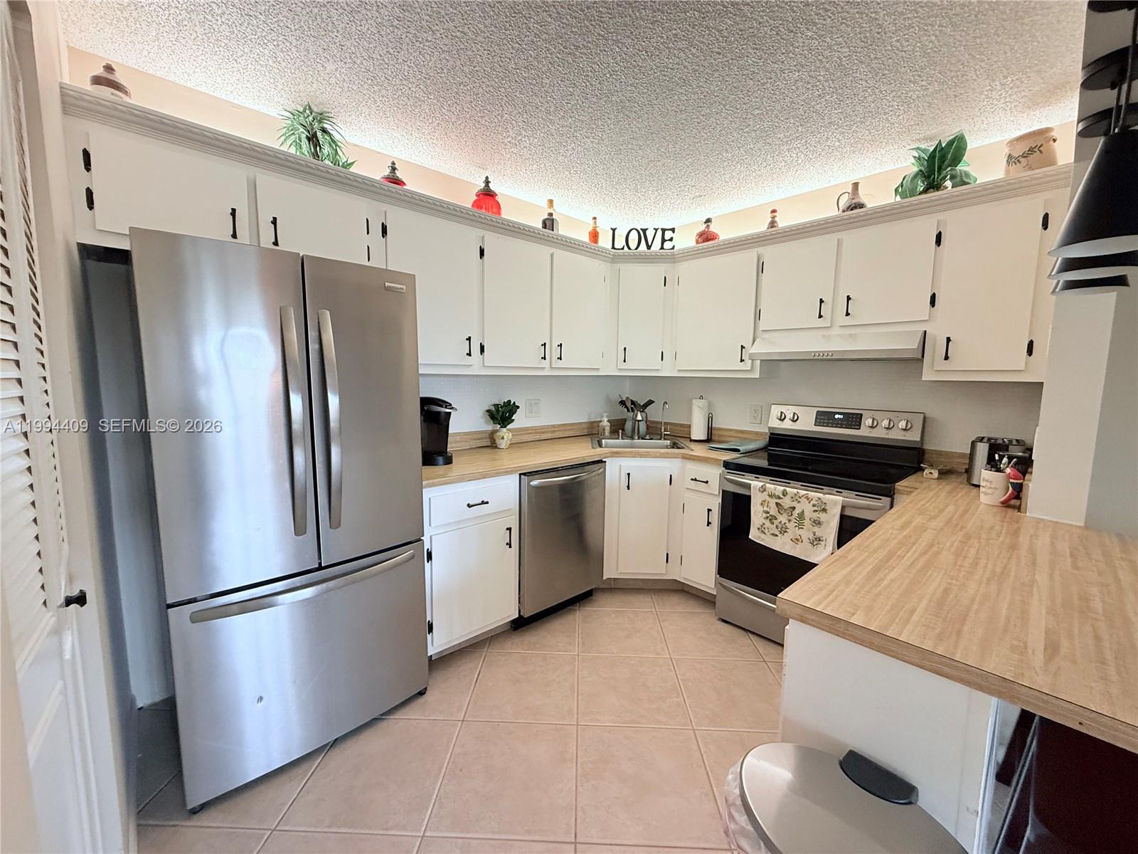 340 Pine Ridge Circle, Unit C1 Greenacres, FL 33463 - Photo 17 of 24 a kitchen with cabinets stainless steel appliances and a counter space