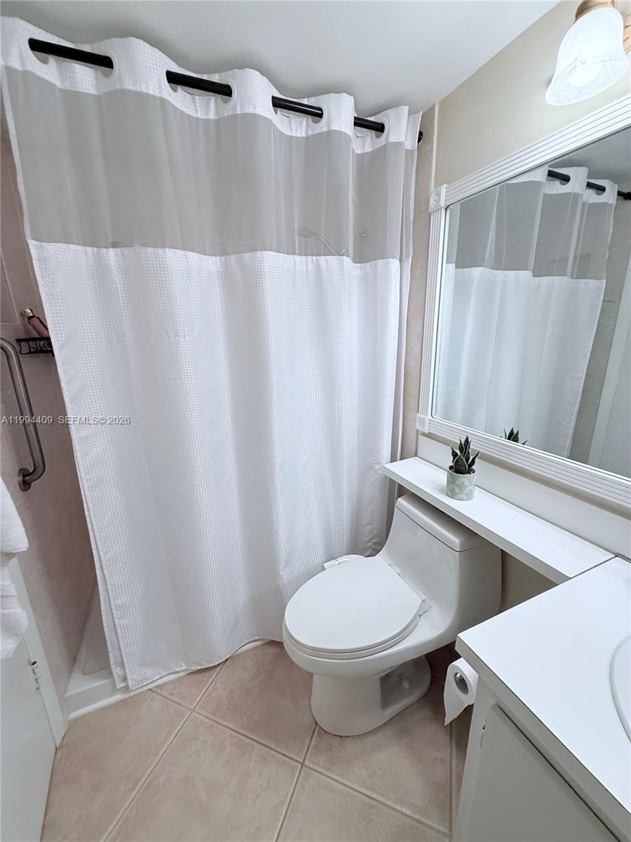 340 Pine Ridge Circle, Unit C1 Greenacres, FL 33463 - Photo 19 of 24 a white toilet sitting next to a bathroom sink