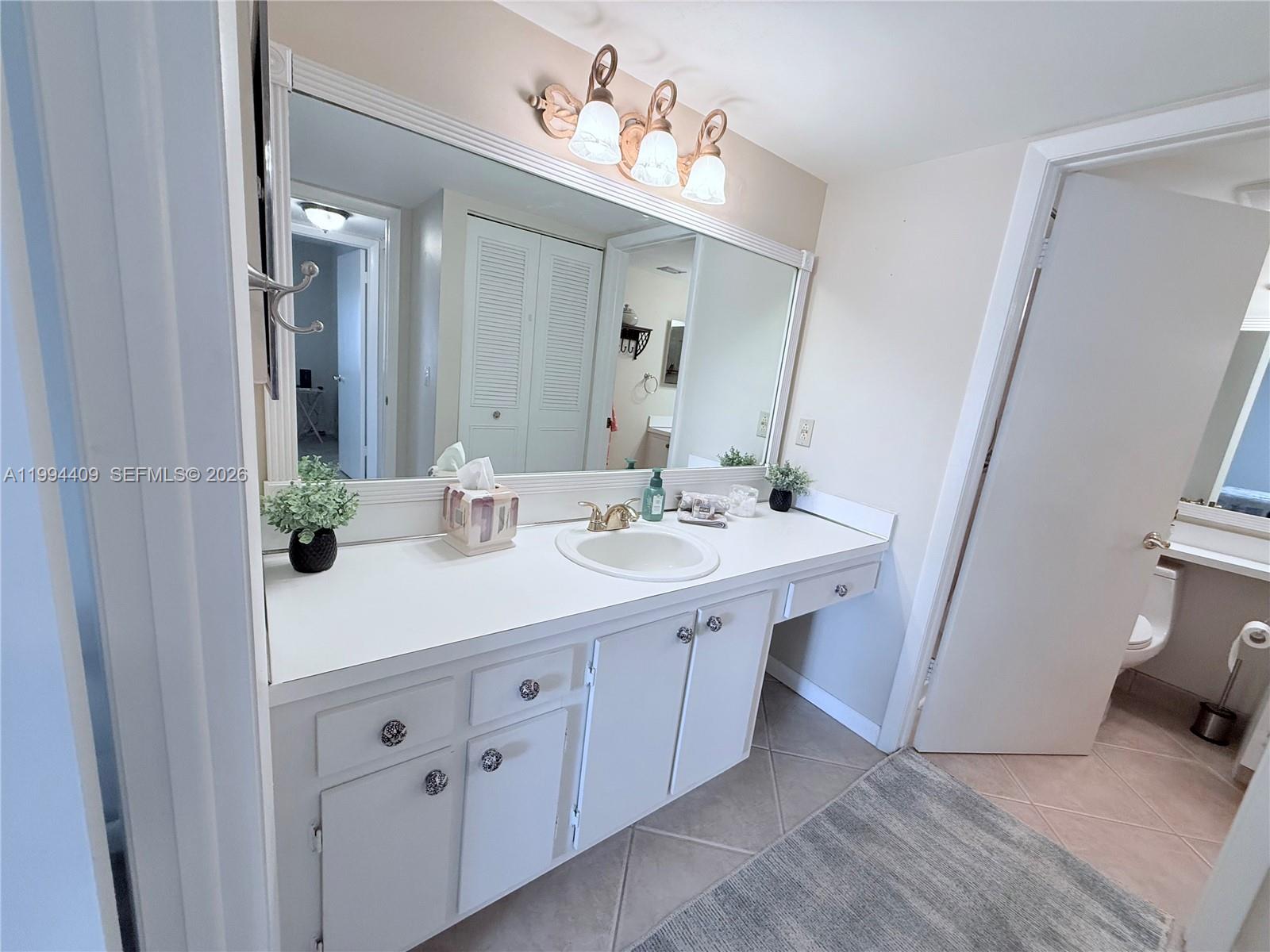 340 Pine Ridge Circle, Unit C1 Greenacres, FL 33463 - Photo 23 of 24 a bathroom with a double vanity sink and a mirror